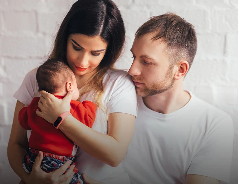 Parents holding their baby together, reflecting attentive care and family engagement